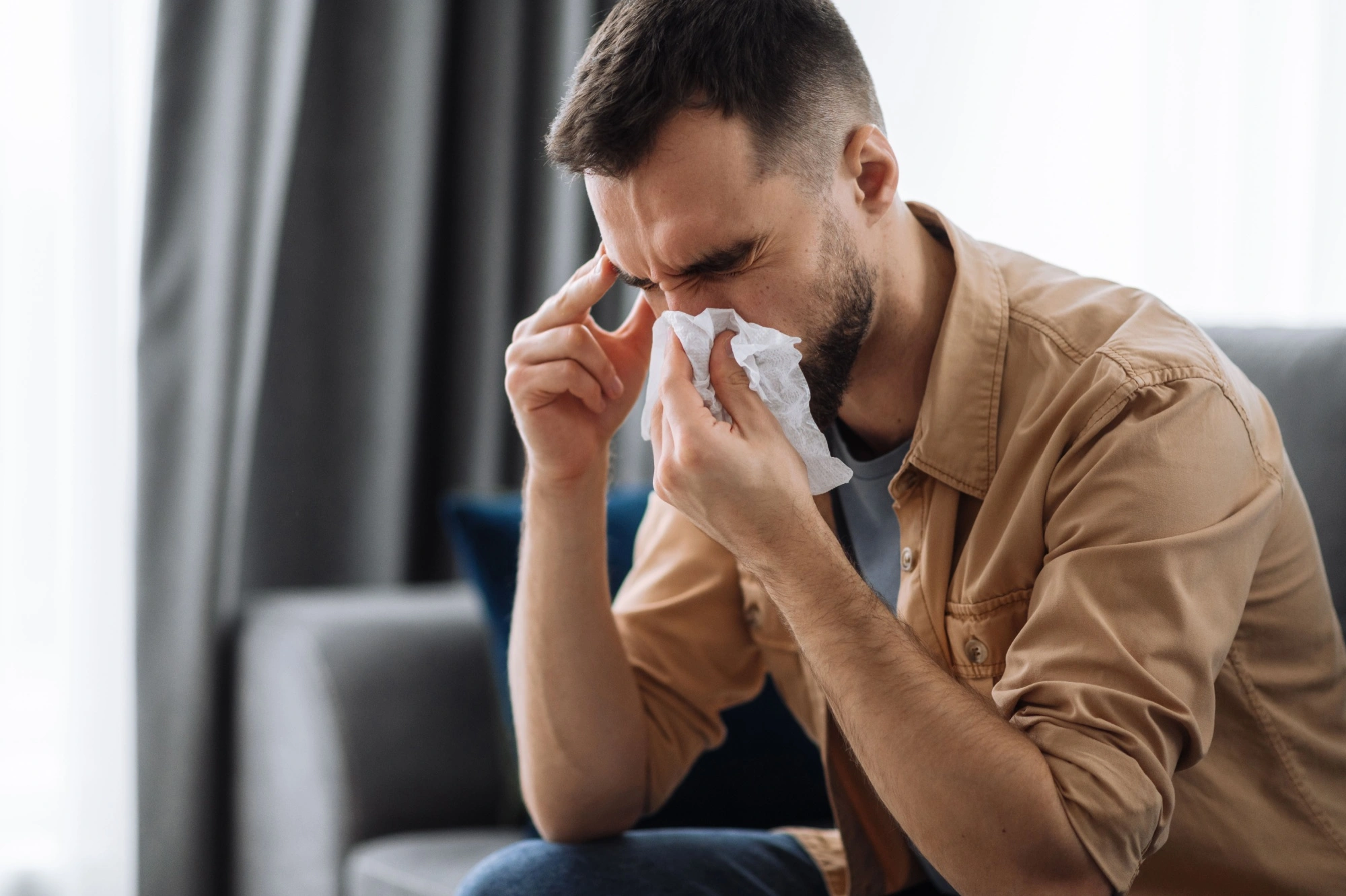 Young man with sinus discomfort due to changes in weather