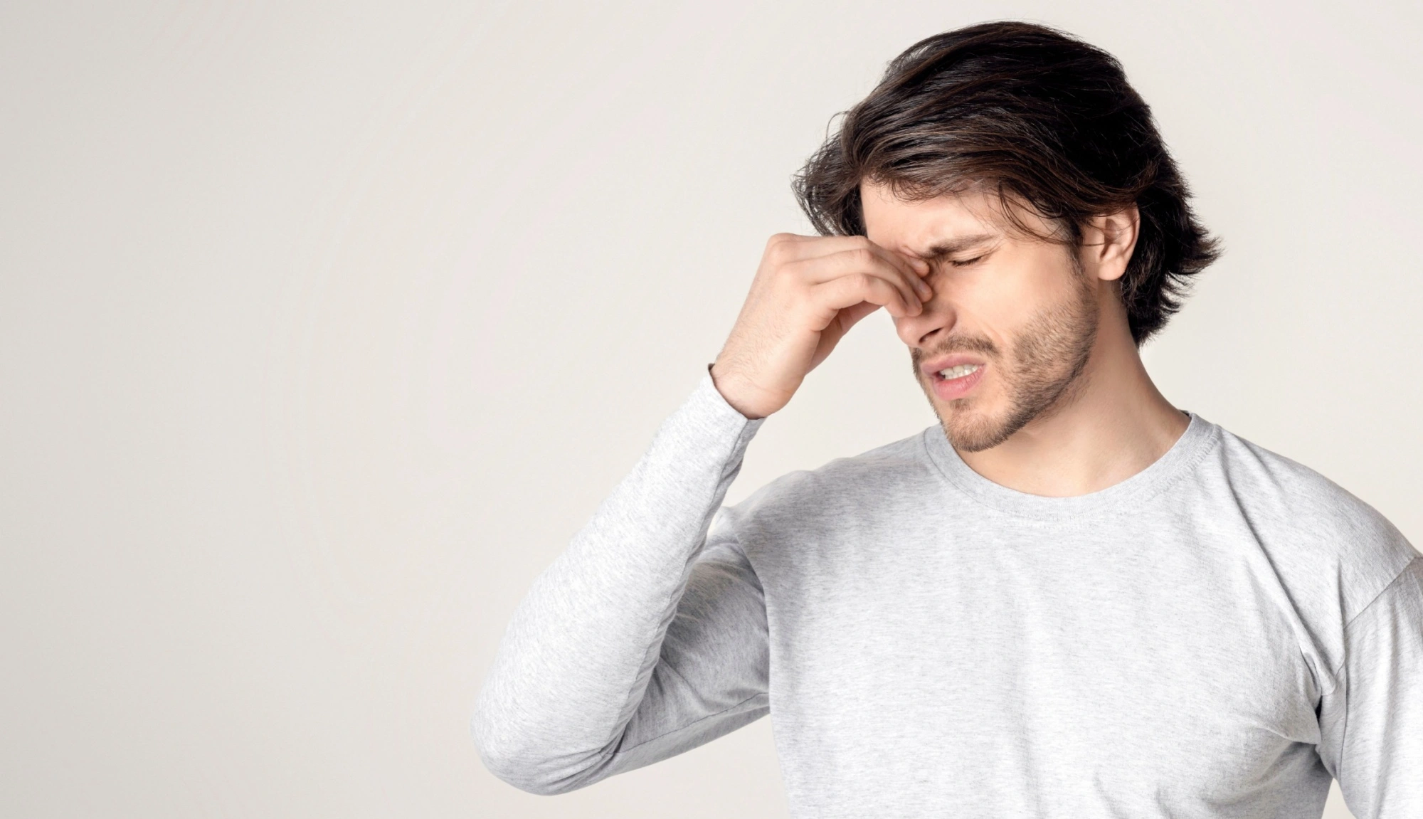 Man with sinus pain holding his nose