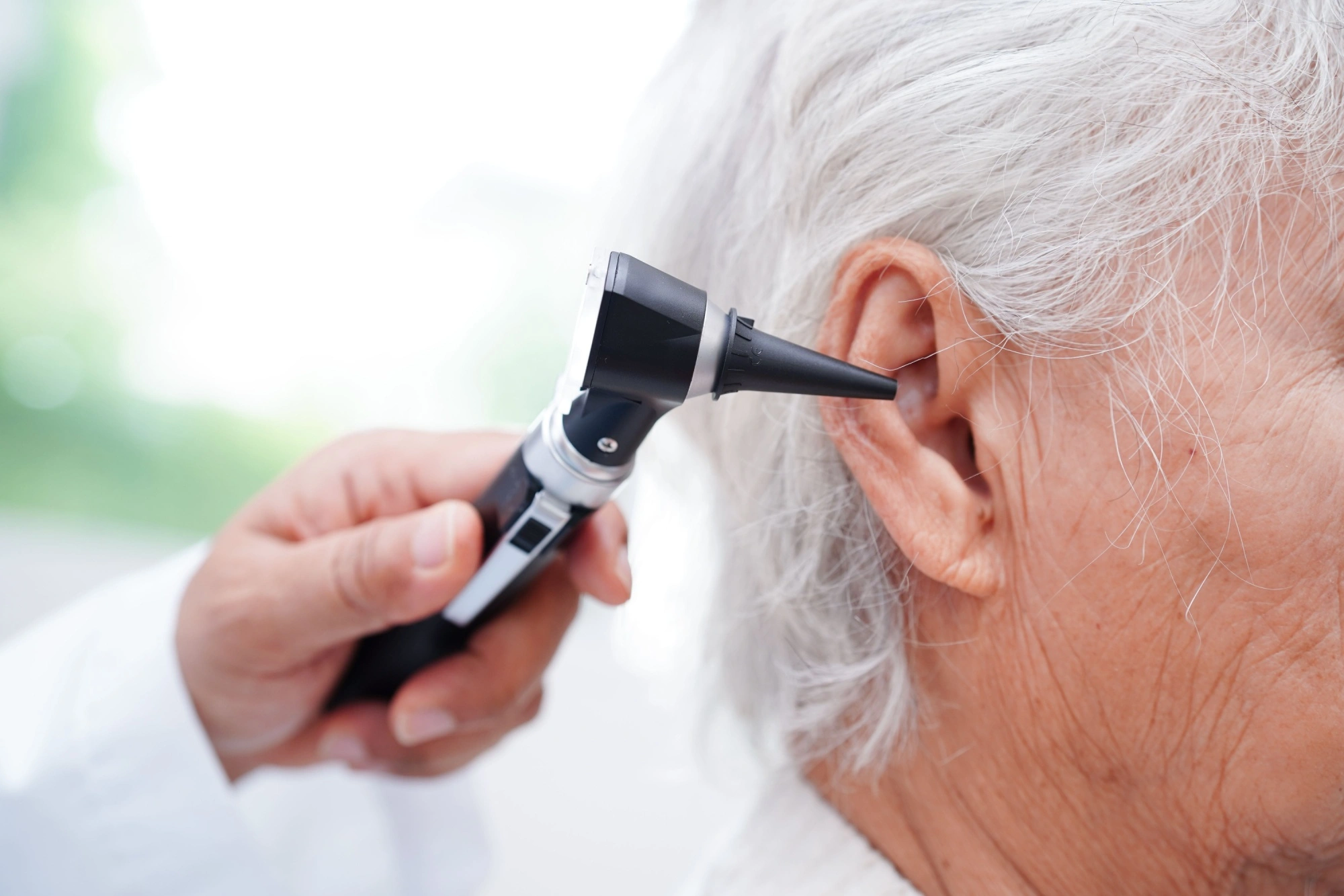 An ENT specialist examining a patient’s ear