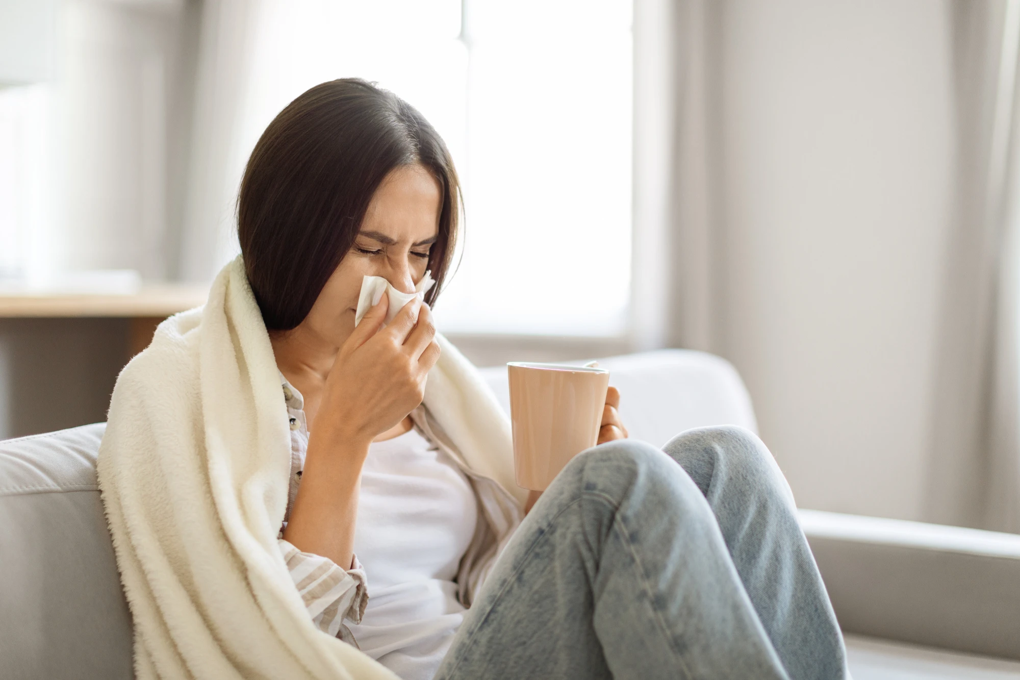 Woman blowing her nose, sick with a sinus infection