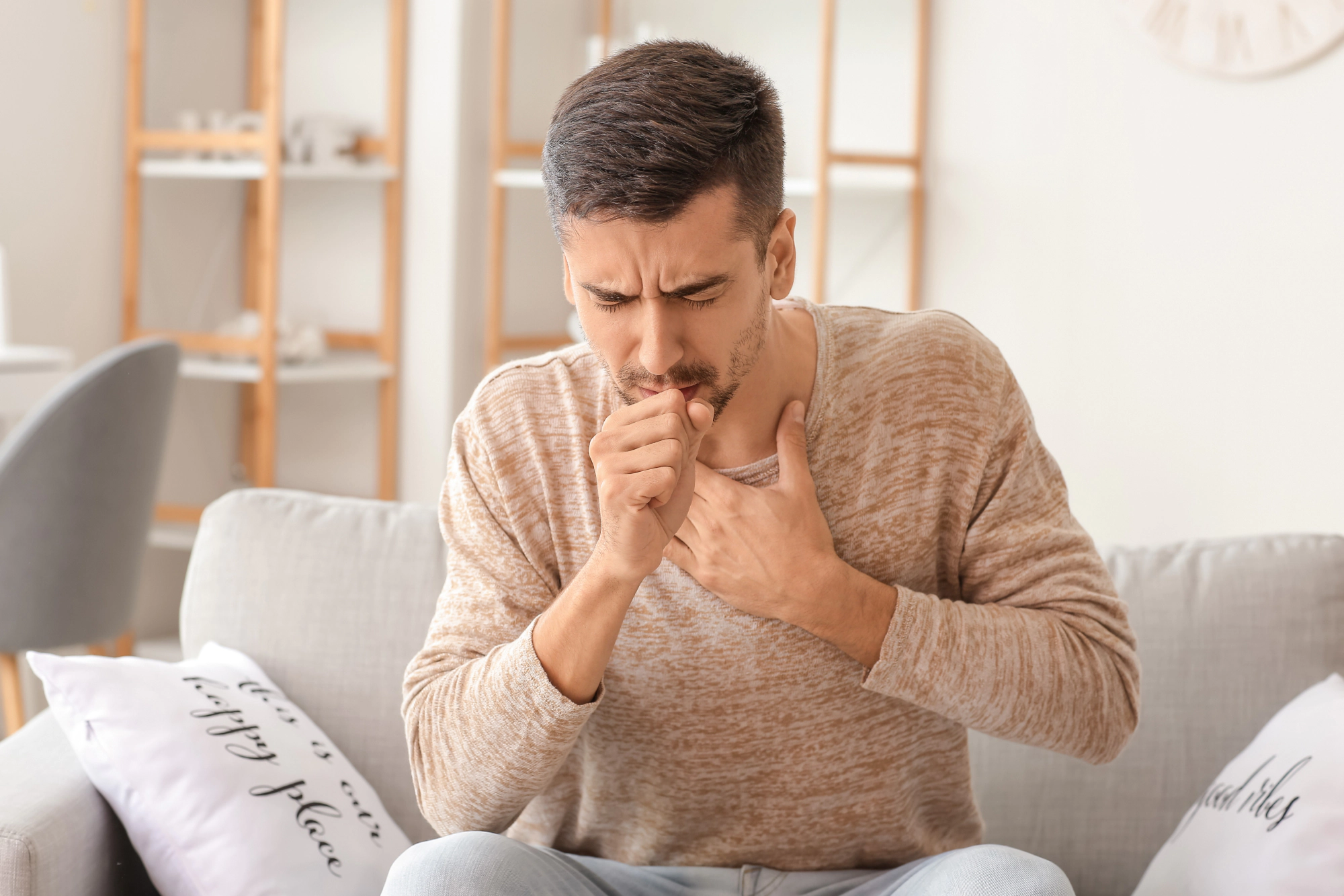 Young man coughing.