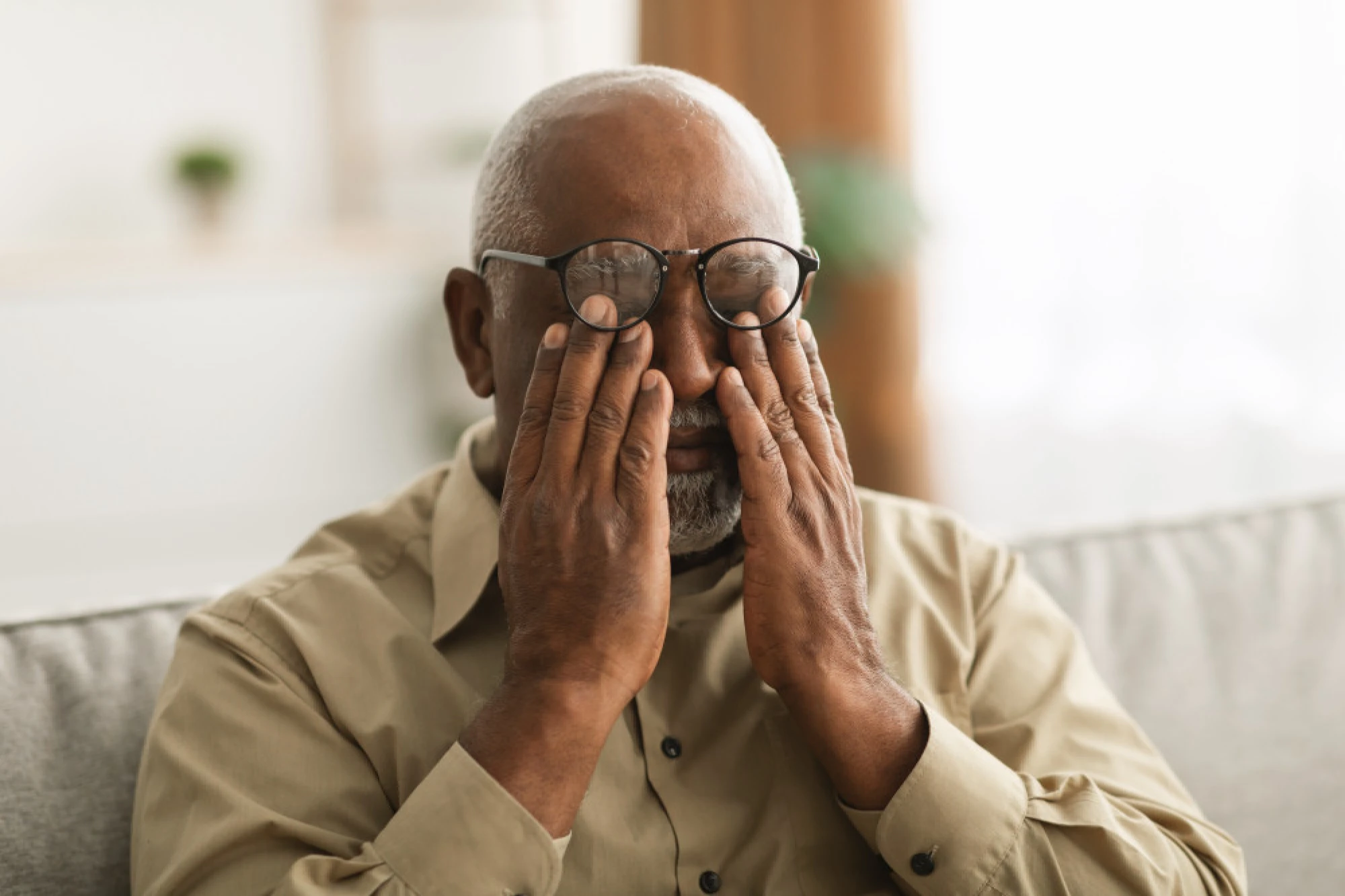Senior black man rubbing his eye in pain