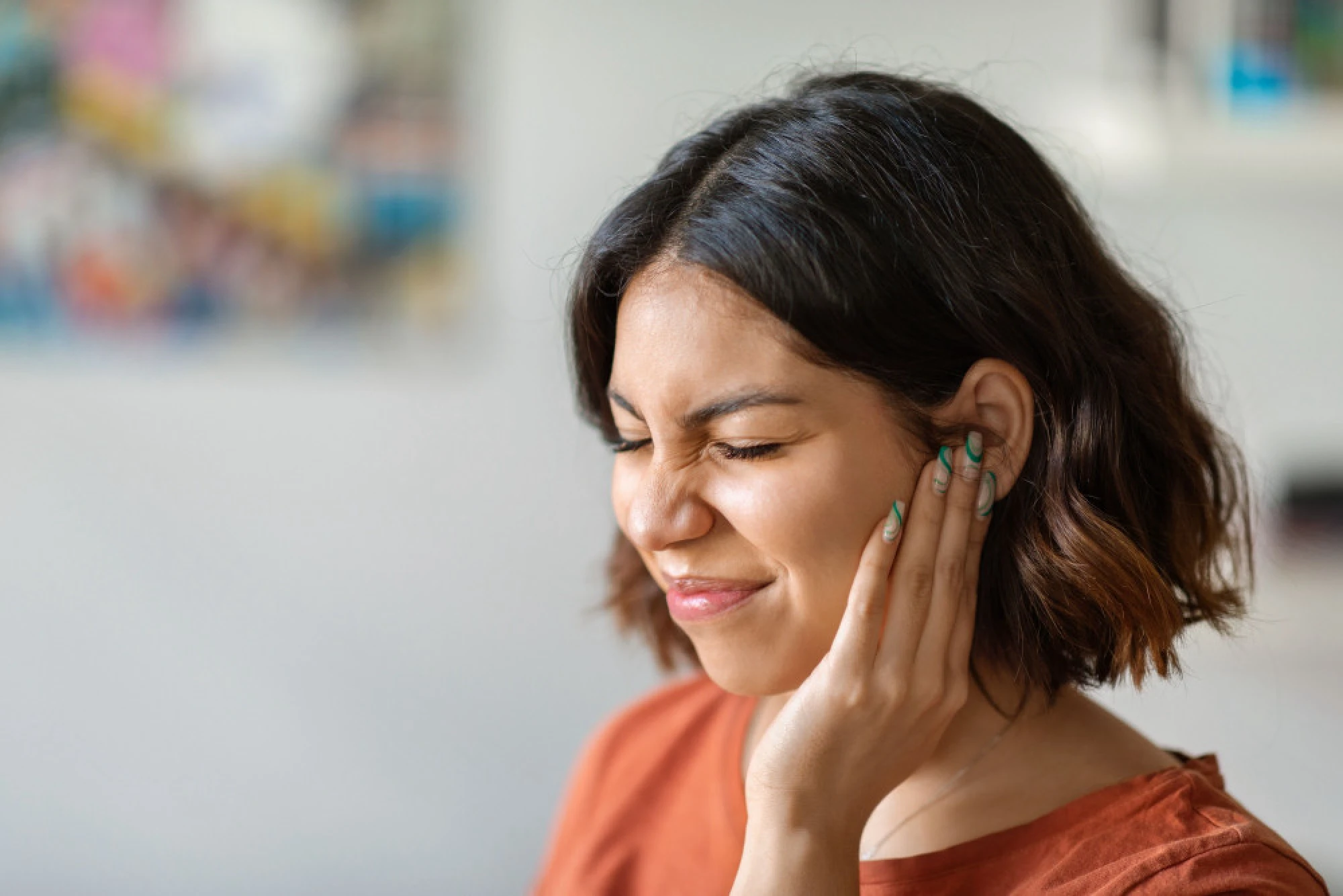 Woman holding her ear in pain due to a swollen ear canal