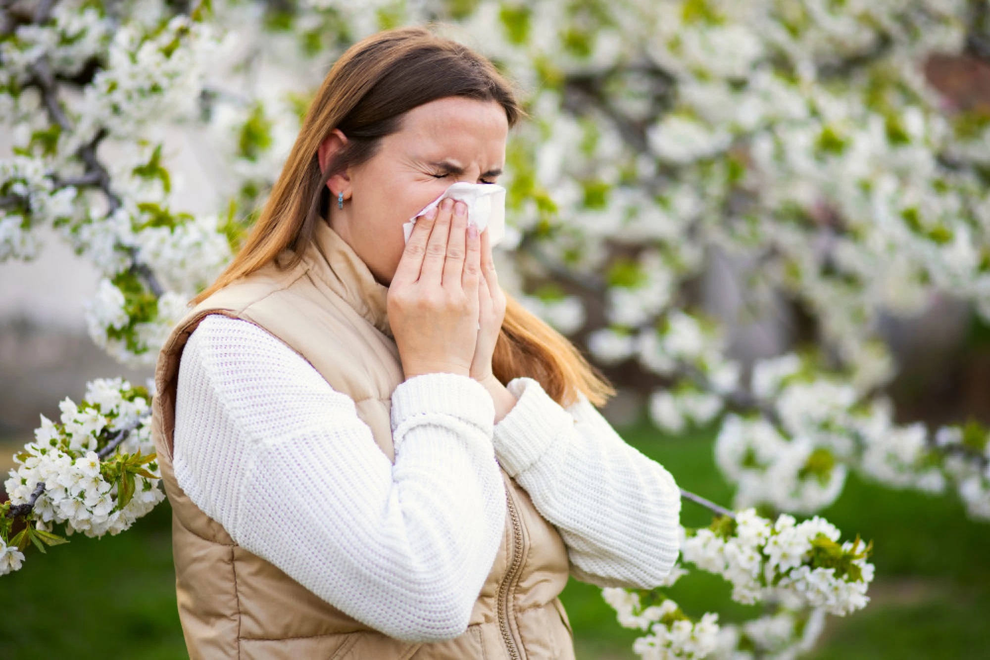 Woman sneezing surrounded by flowers
