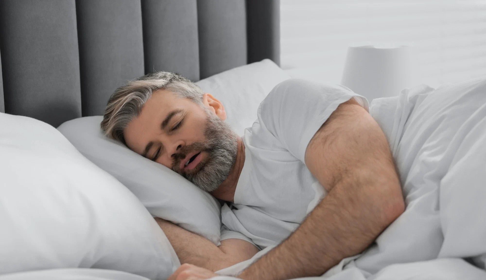Man snoring while sleeping on his side in Houston