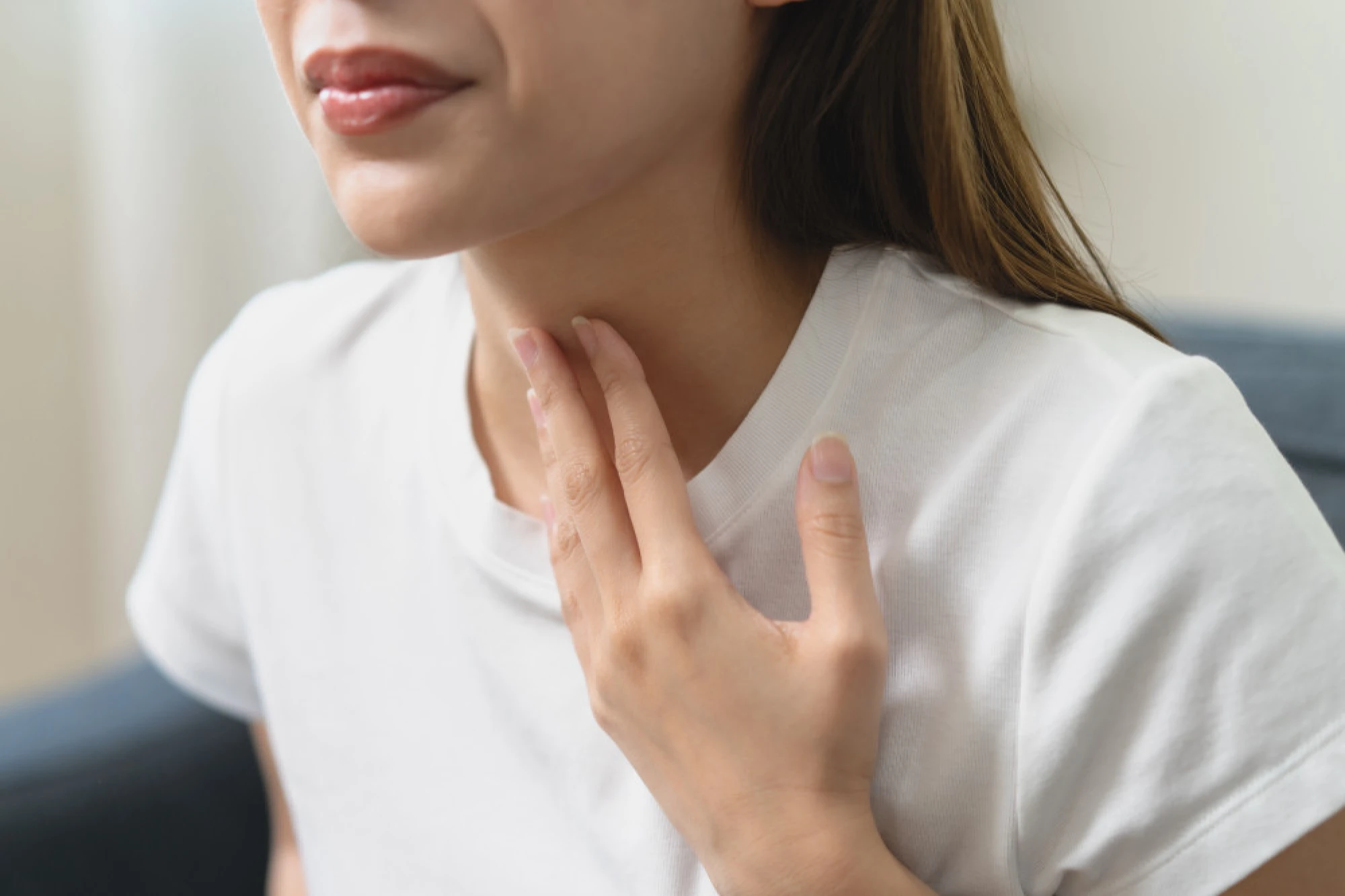 Woman holding her throat in pain