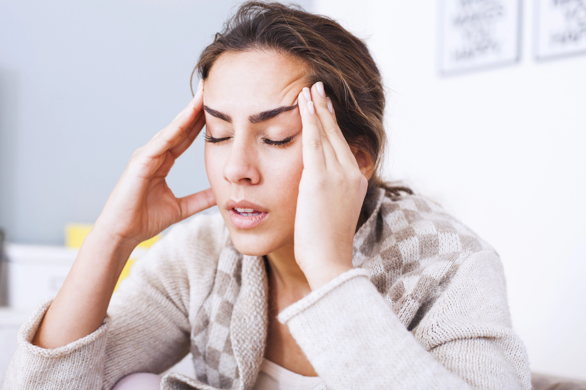 Woman with headache holding hands on head